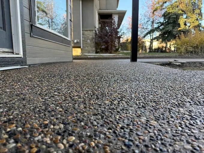 Ground-level view of gravel driveway in front of modern residential home.