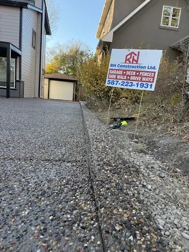 RN Construction Ltd yard sign on gravel driveway between residential houses
